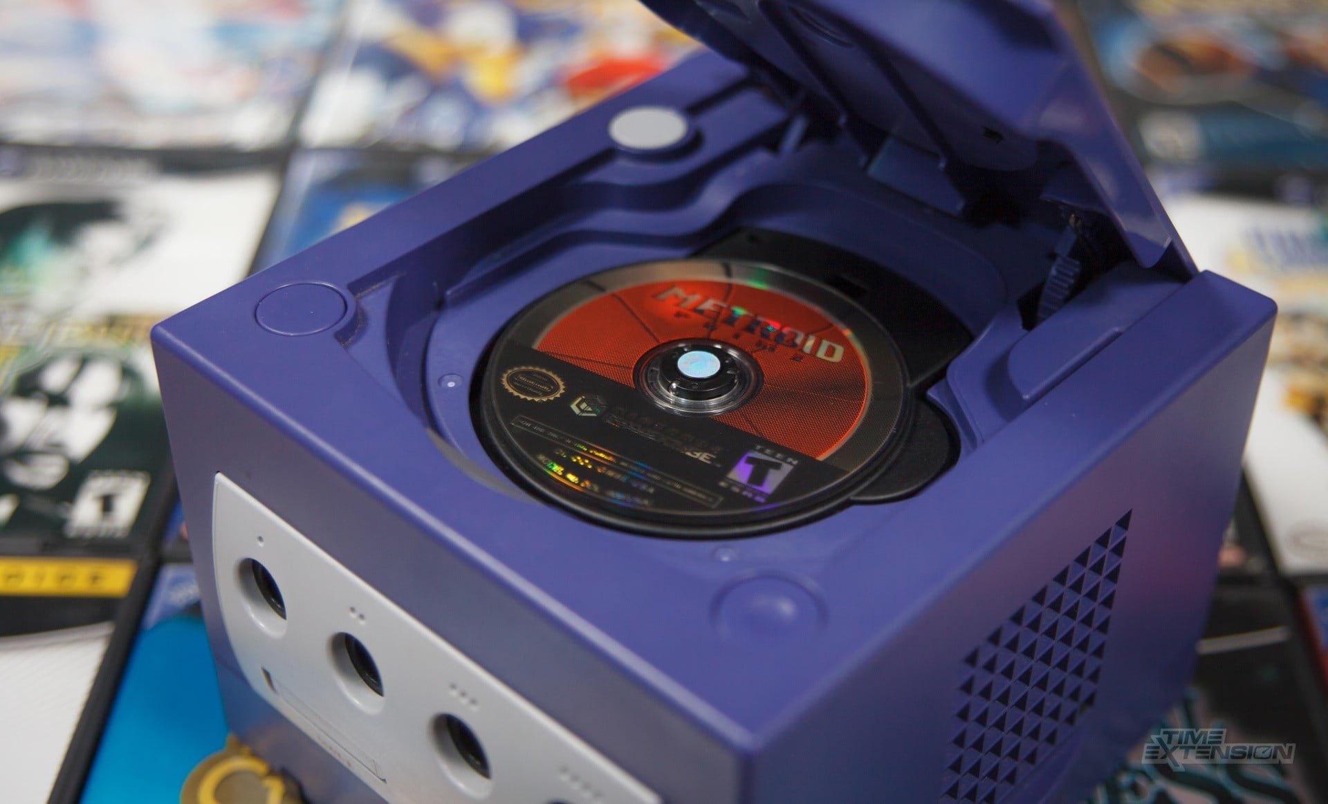 A stack of classic console game discs beside a PC Blu-ray drive.